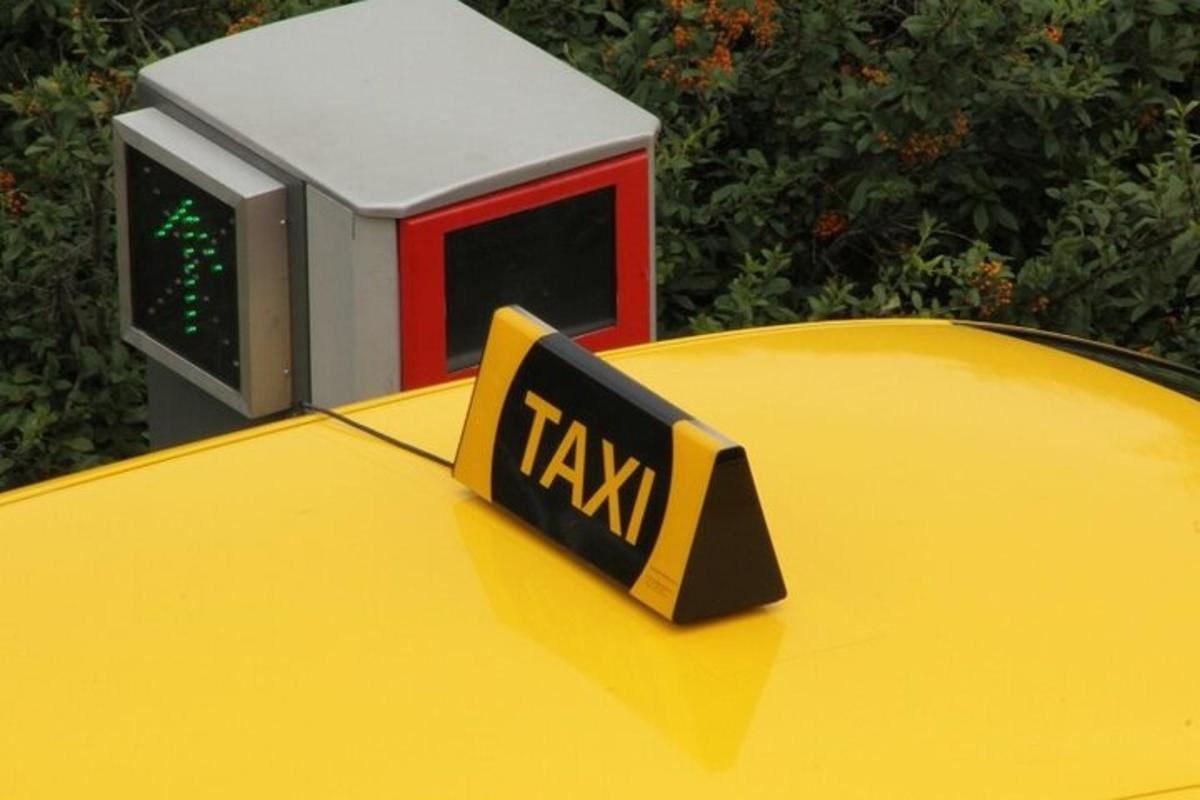uma placa de táxi em cima de um carro amarelo