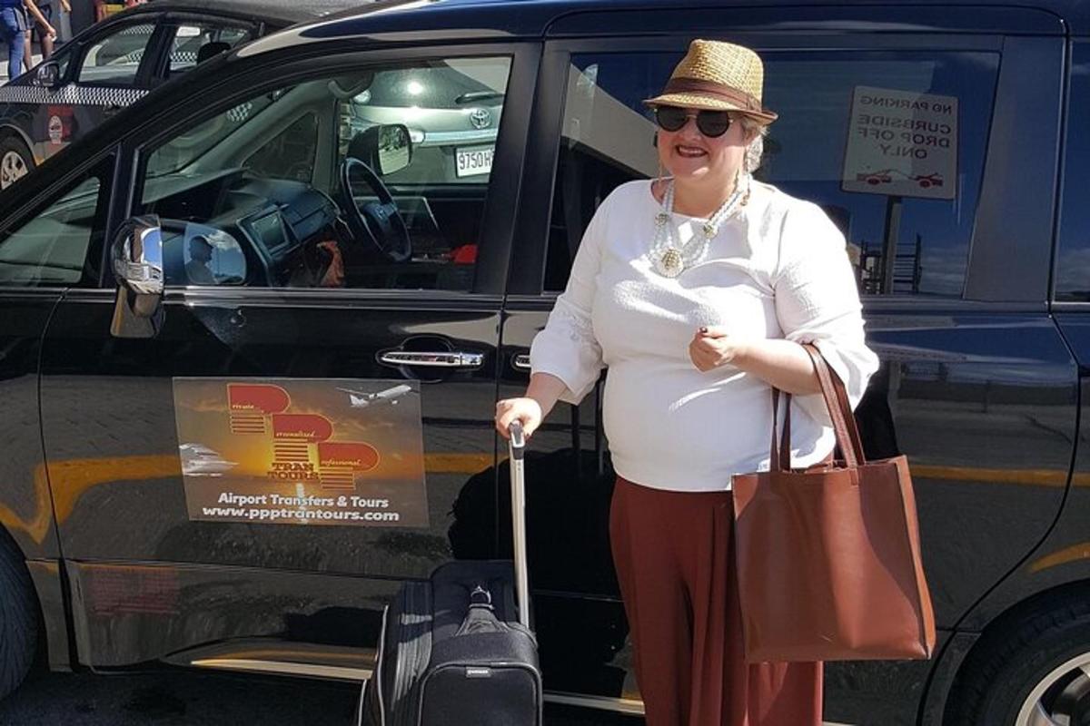 a woman standing in front of a car with luggage
