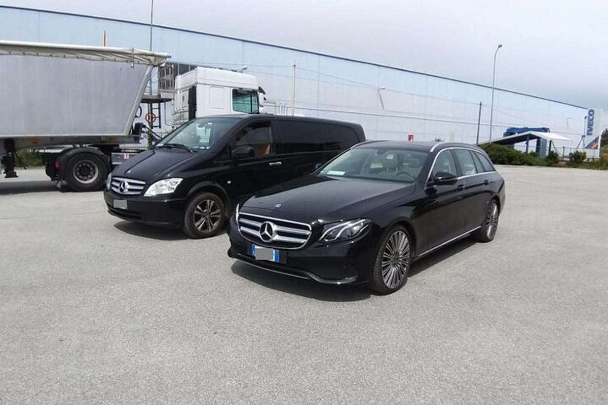 two black cars parked next to a truck