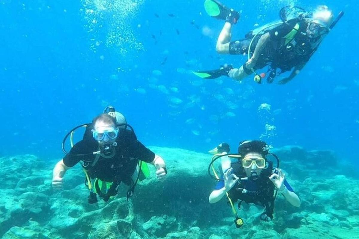 trei persoane fac scufundări în ocean