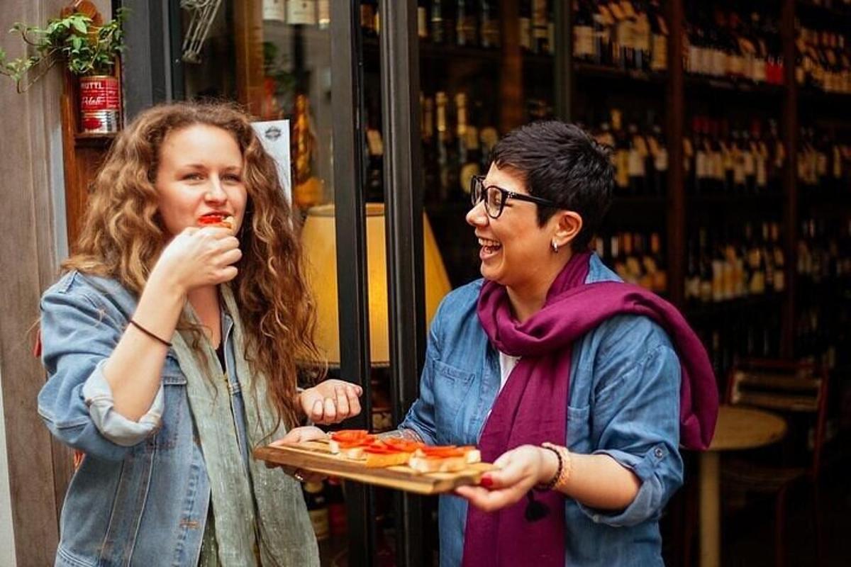 zwei Frauen essen Pizza und eine hält ein Tablett mit Pizza