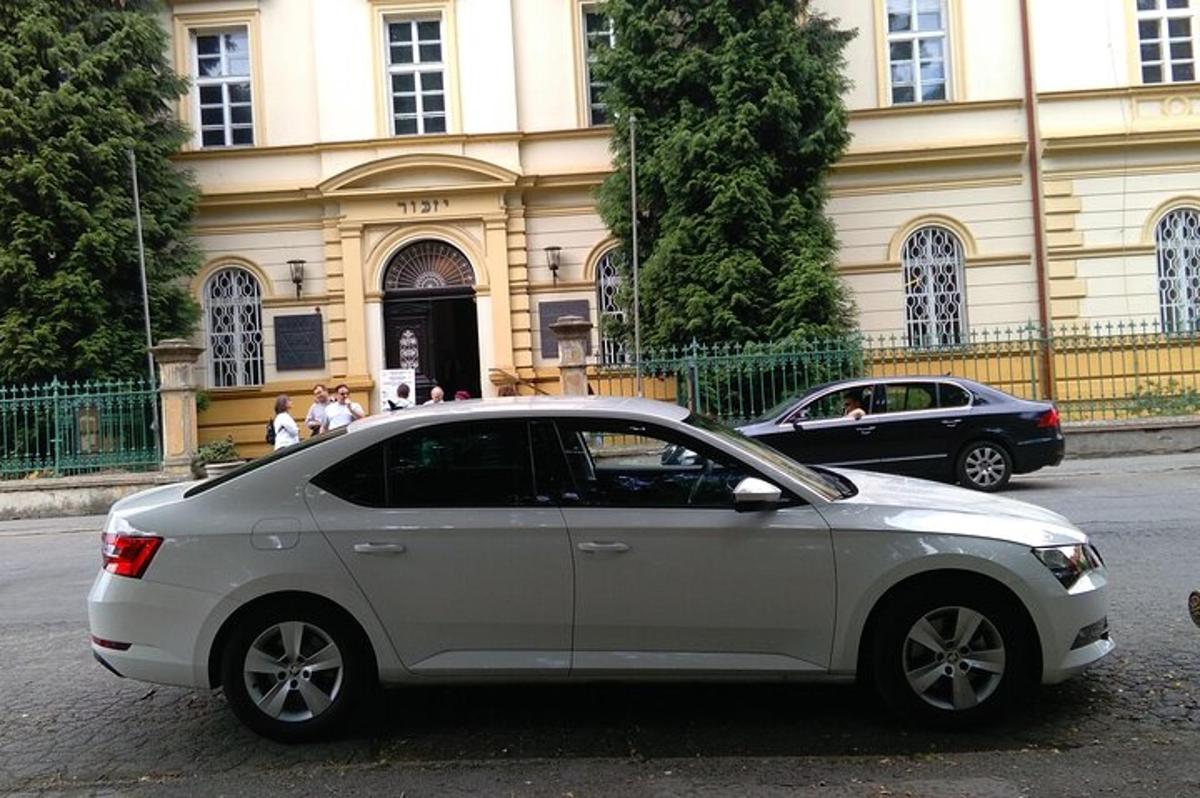 Un coche blanco aparcado delante de un edificio