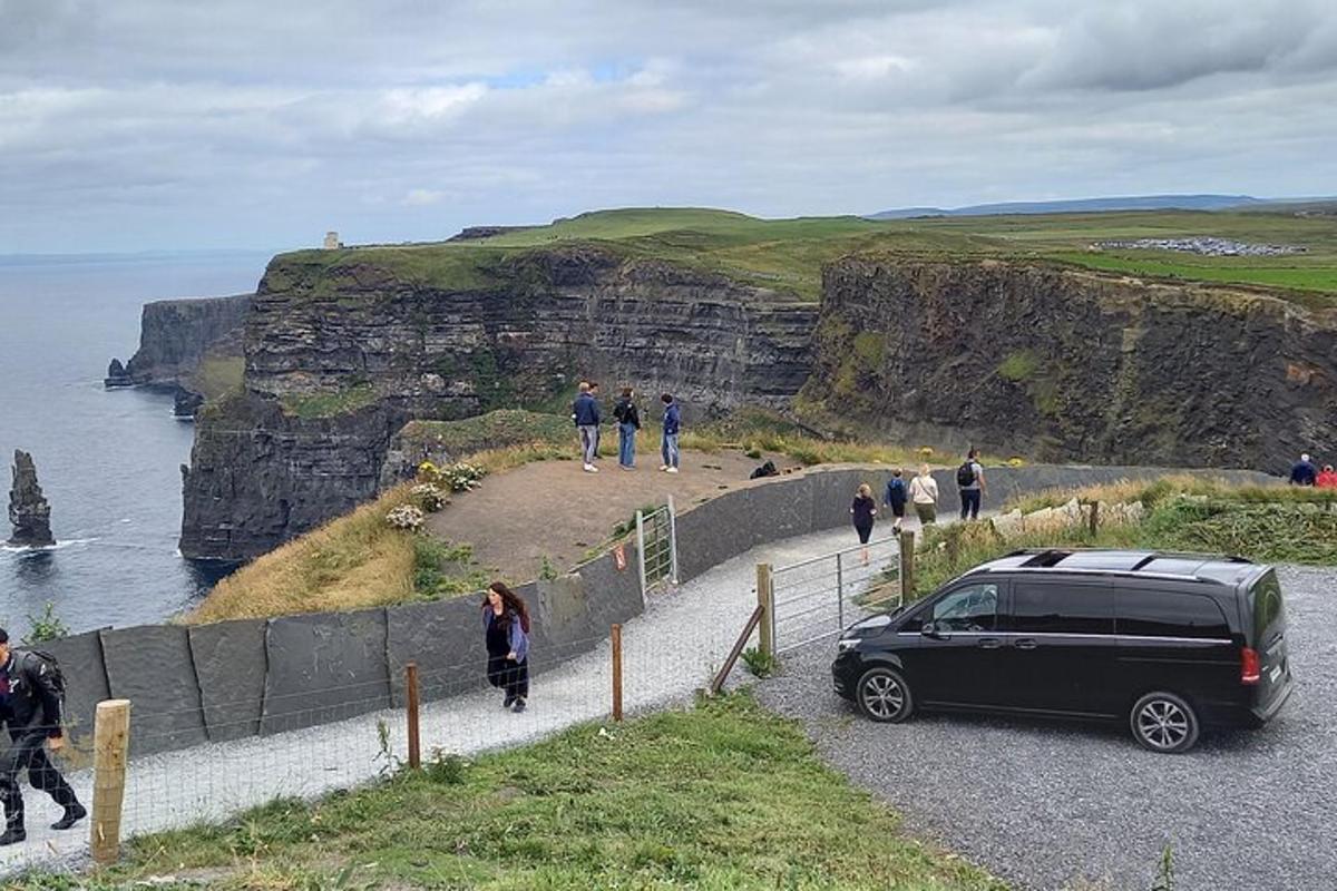 en svart bil parkert på siden av en klippe