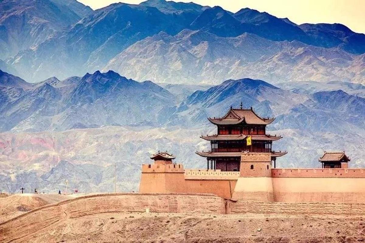 un edificio su una collina con le montagne sullo sfondo