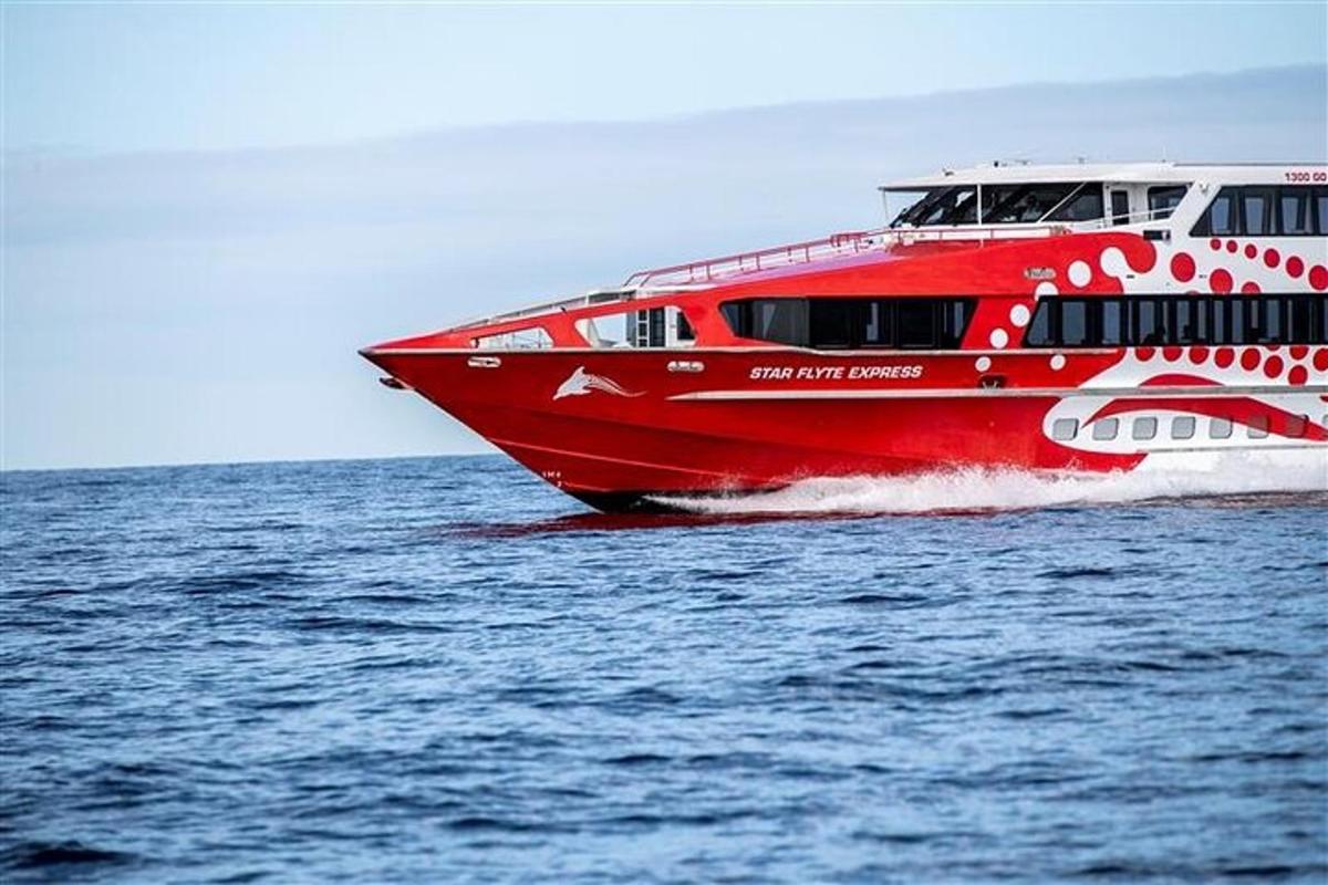 a red ferry boat on the water