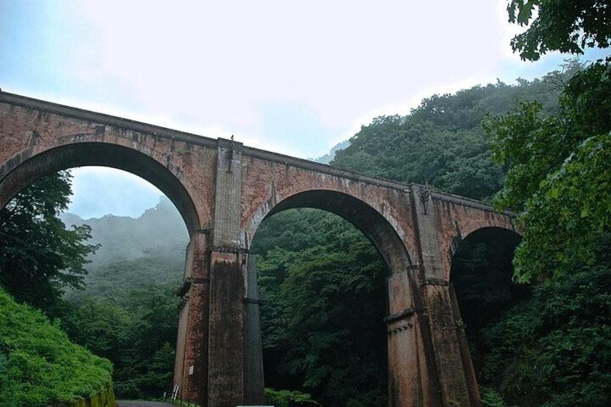 isang lumang tulay na bato na may dalawang arko sa isang bundok