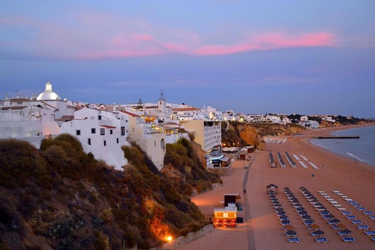 Una vista de una playa con un grupo de coches aparcados.