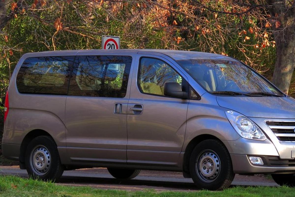 uma van prateada estacionada na beira de uma rua