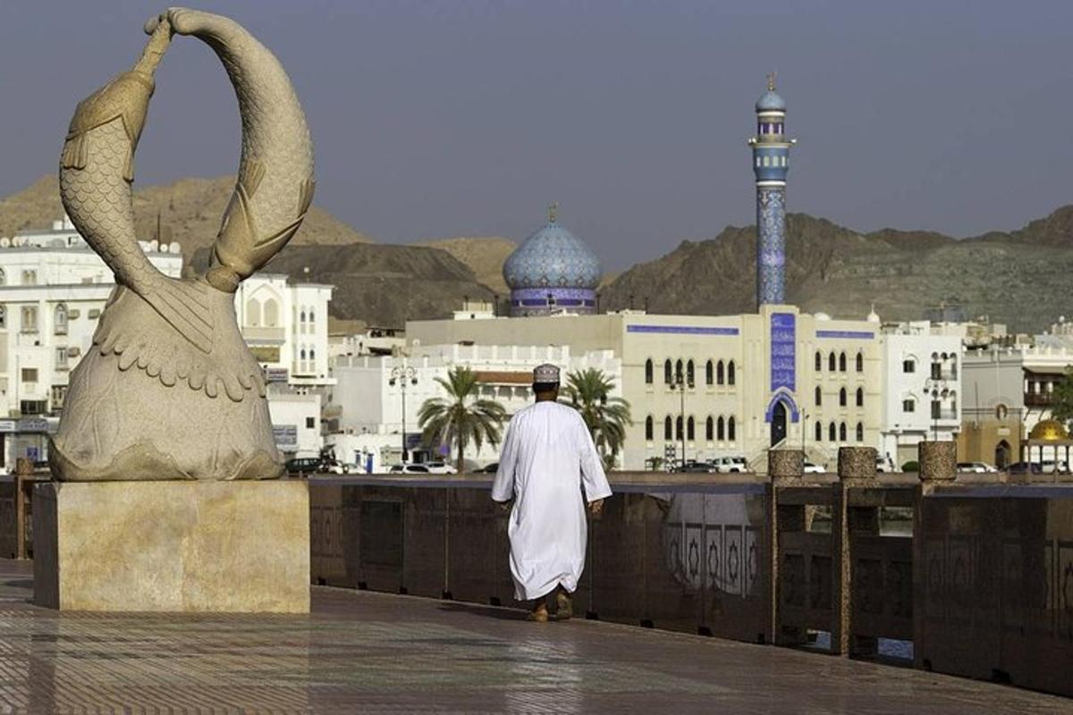 a man walking on a ledge with a statue of two swans