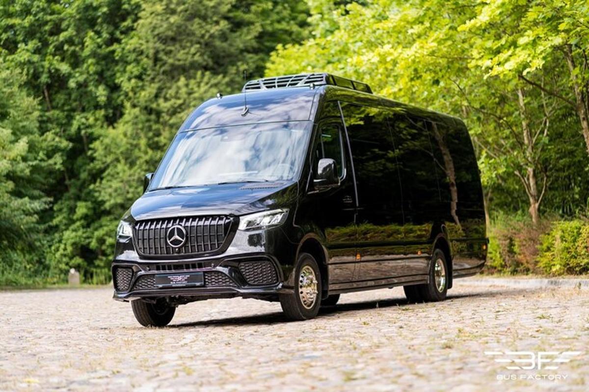 een zwarte bestelwagen staat geparkeerd op de weg