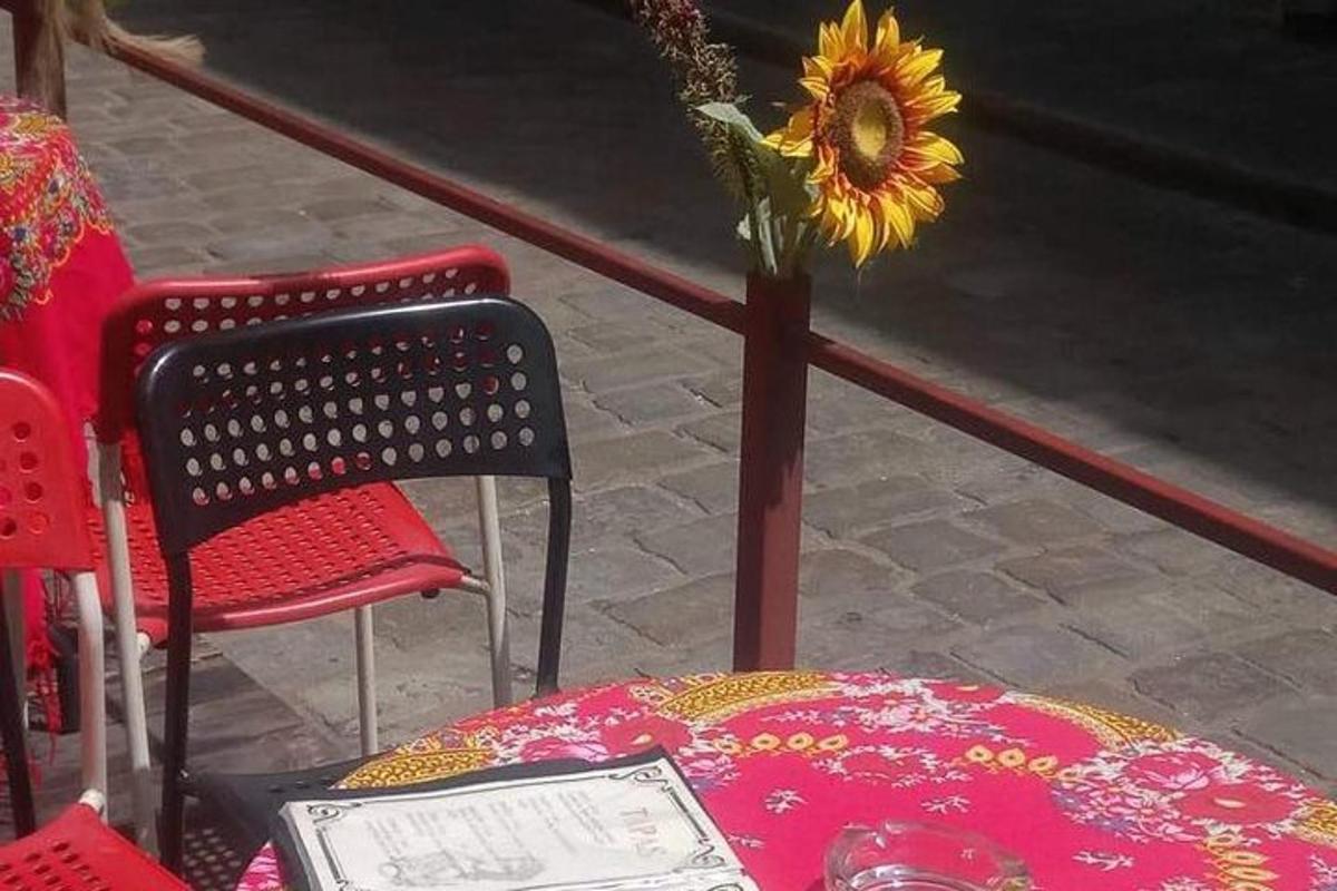 isang mesa at dalawang upuan at isang plorera na may sunflower