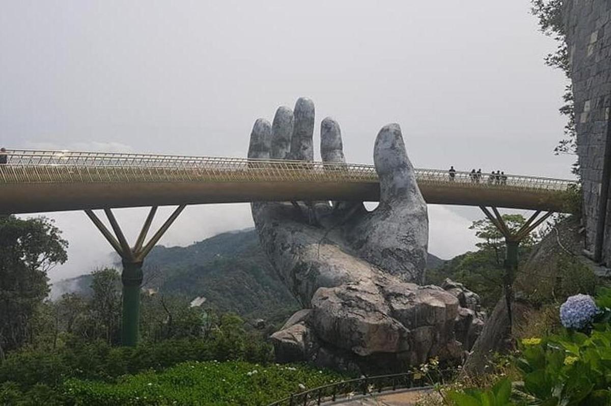 uma ponte sobre uma grande mão segurando uma ponte sobre uma montanha
