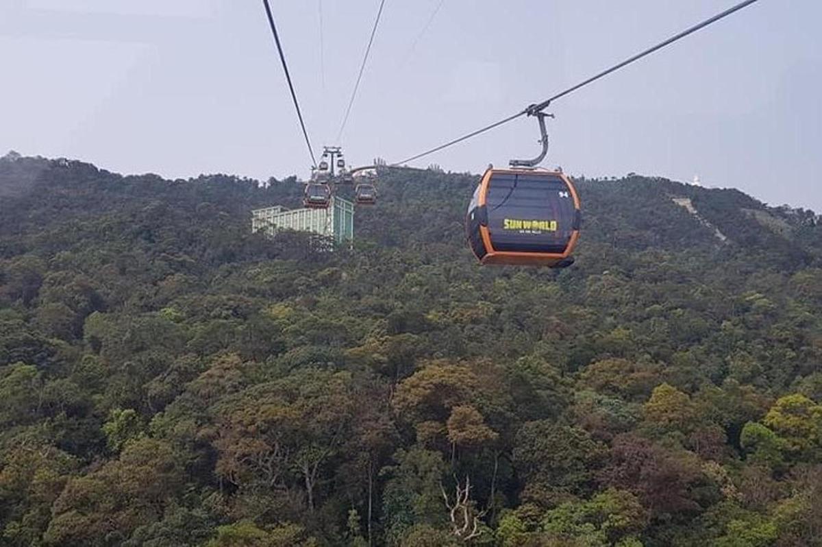 oranžová lanovka letící nad lesem