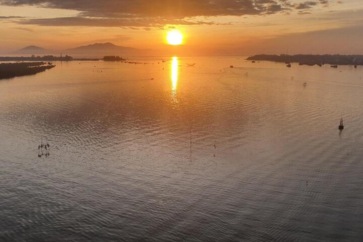 Захід сонця над водоймою з птахами у воді