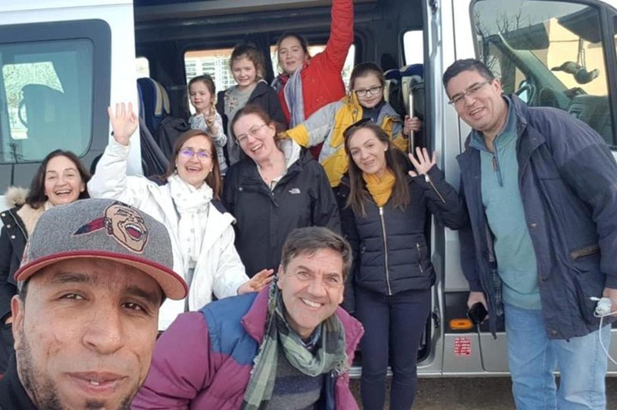 a group of people standing in front of a bus