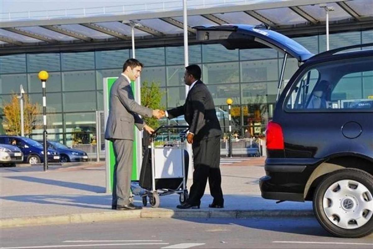 two men shaking hands in front of a car