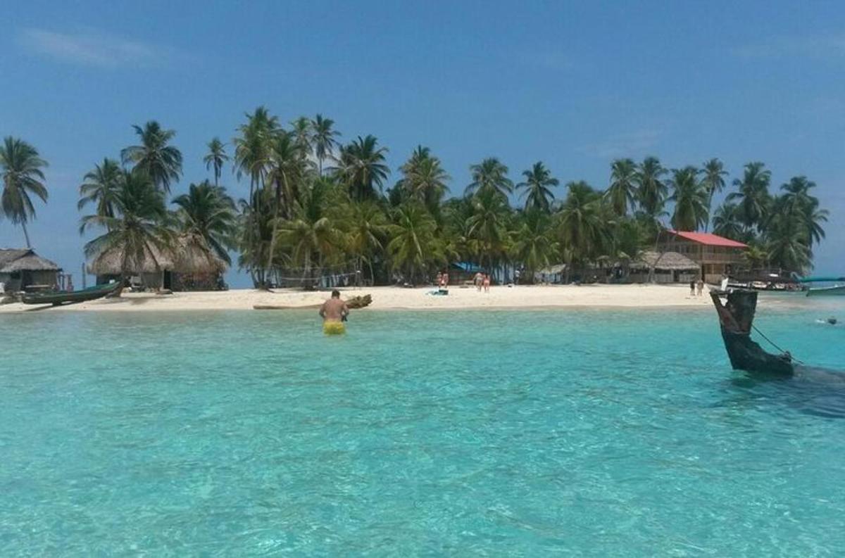 seorang lelaki berdiri di dalam air di hadapan pantai