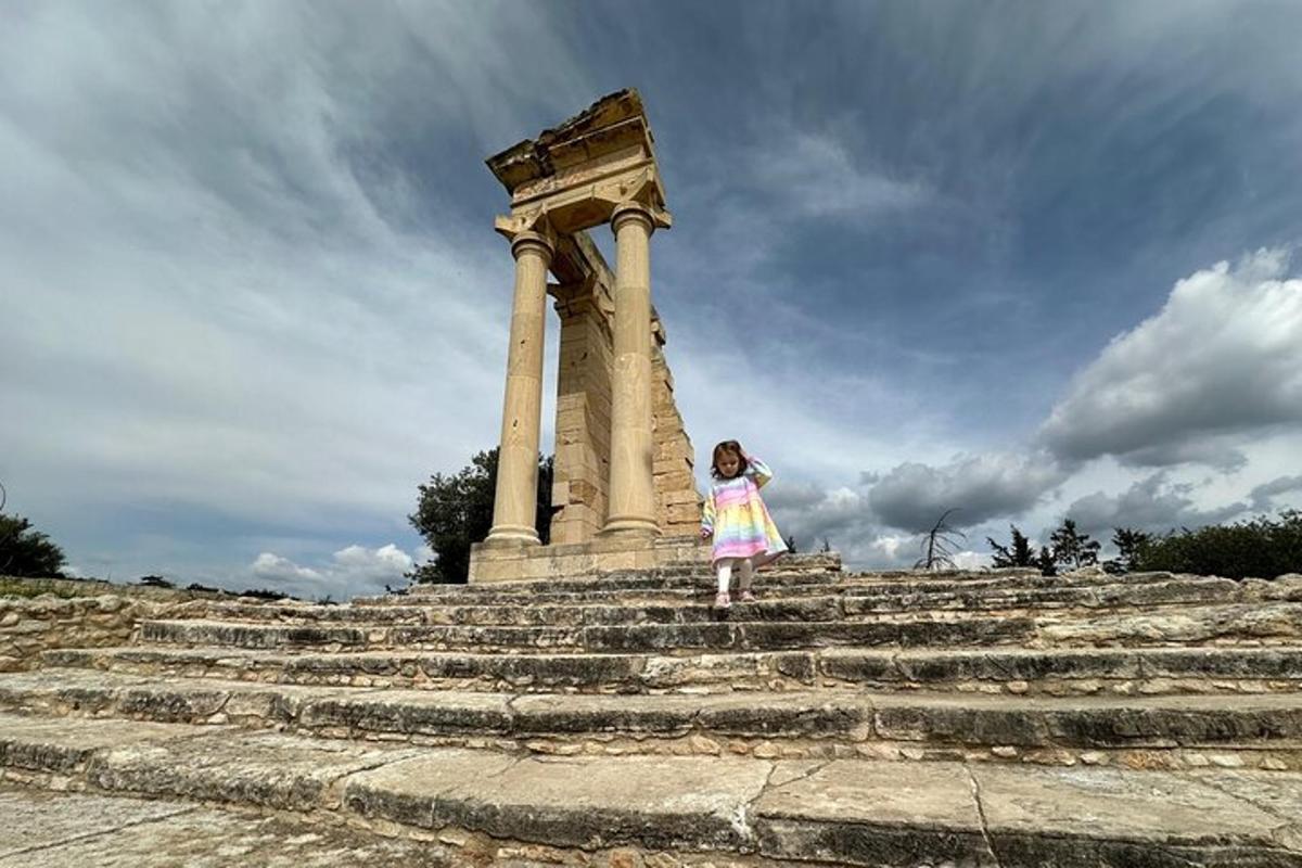Una niña parada en unos escalones frente a un monumento.