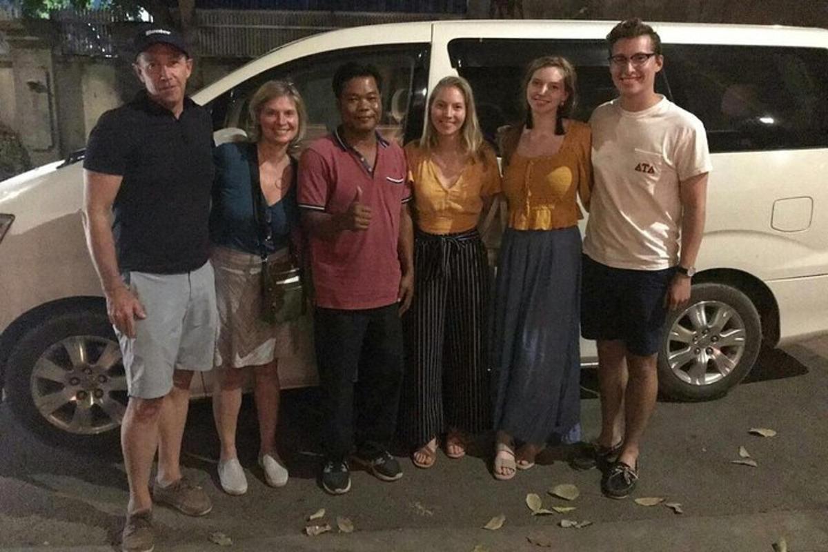 a group of people standing in front of a car