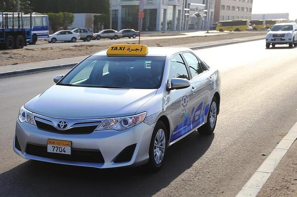 um carro branco com uma placa na beira da estrada