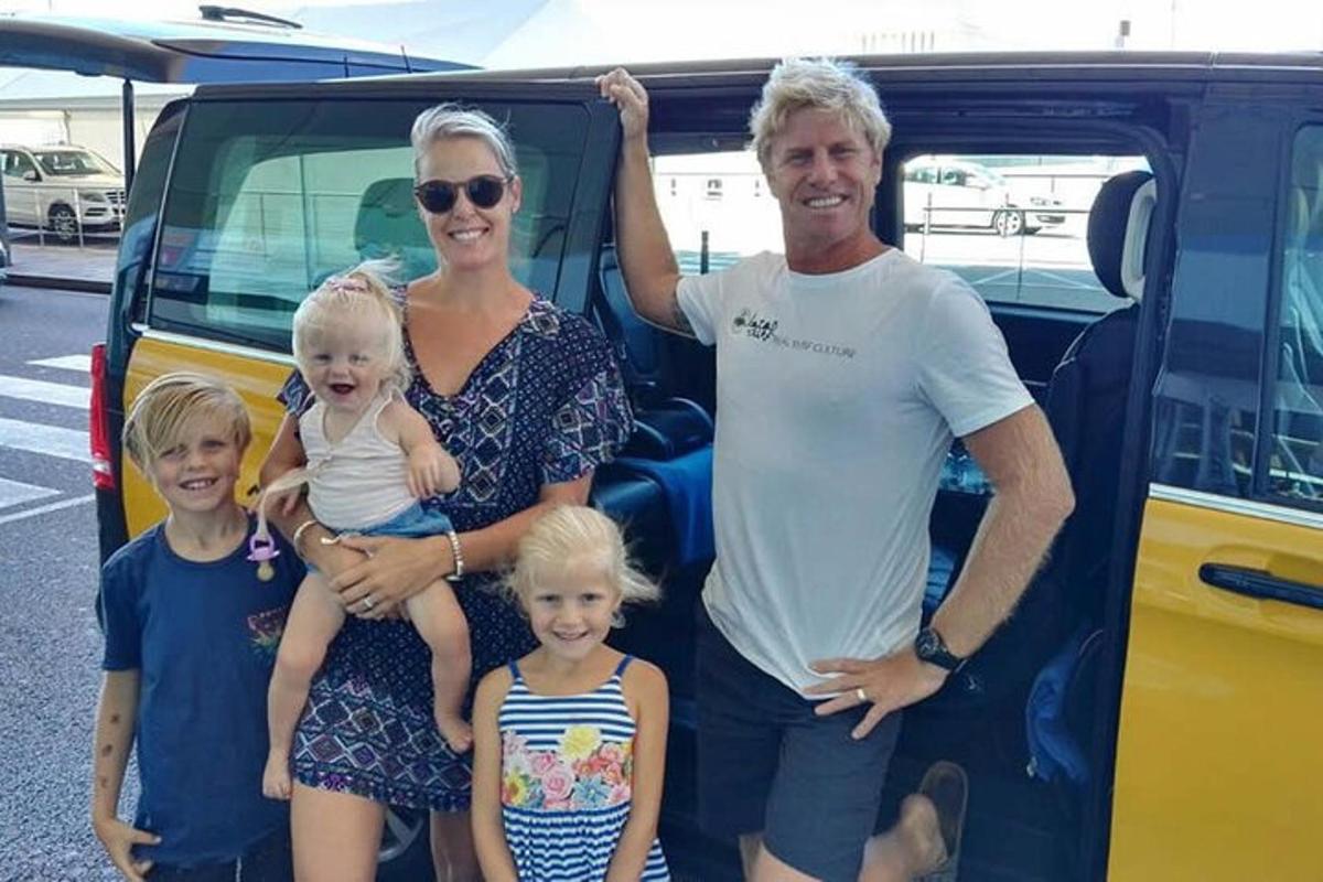 uma família posa em frente a uma van