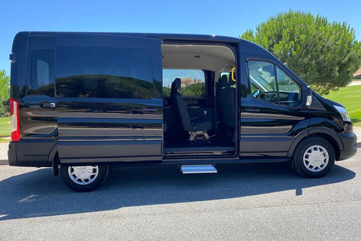 ドアを開けたまま駐車場に駐車された黒いバン