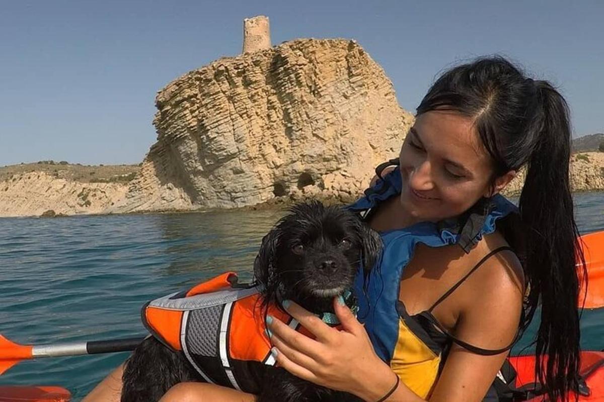 ženska, ki drži črnega psa v čolnu