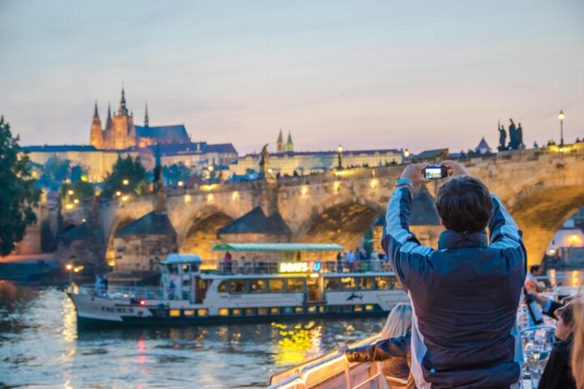 a man taking a picture of a river and a bridge