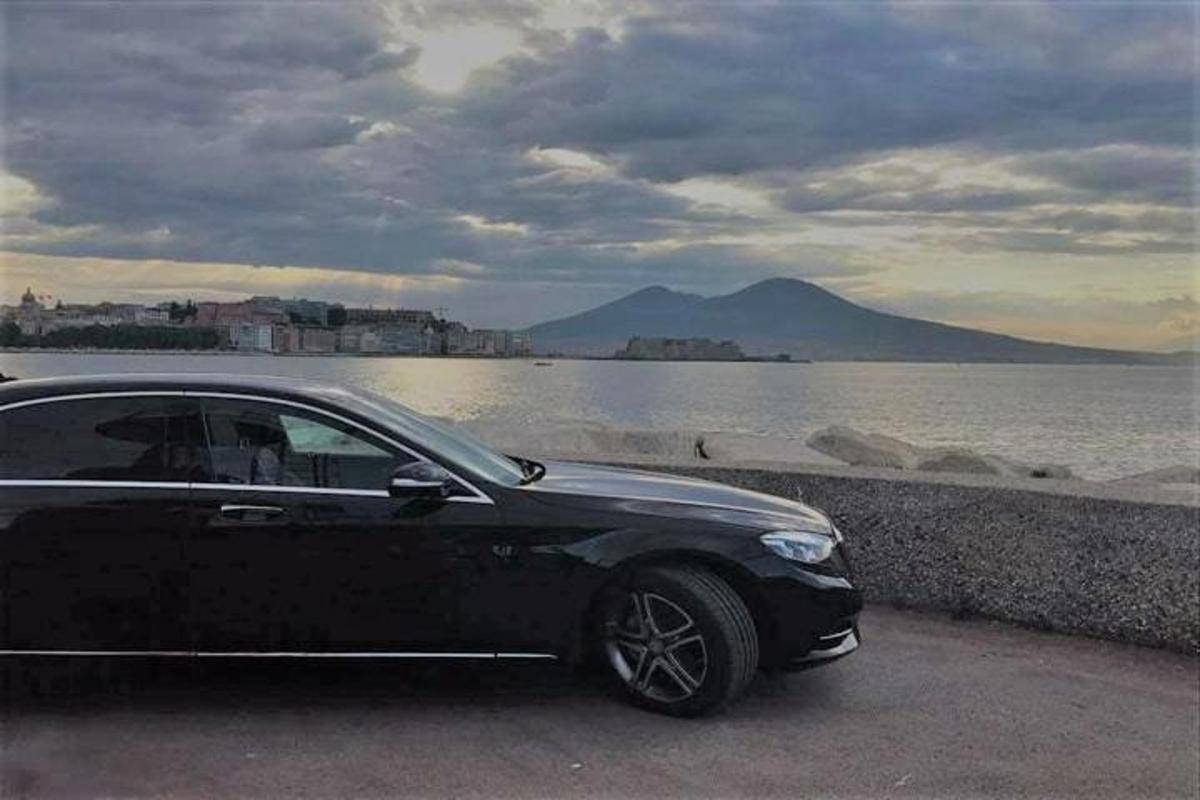 un'auto nera parcheggiata accanto a uno specchio d'acqua
