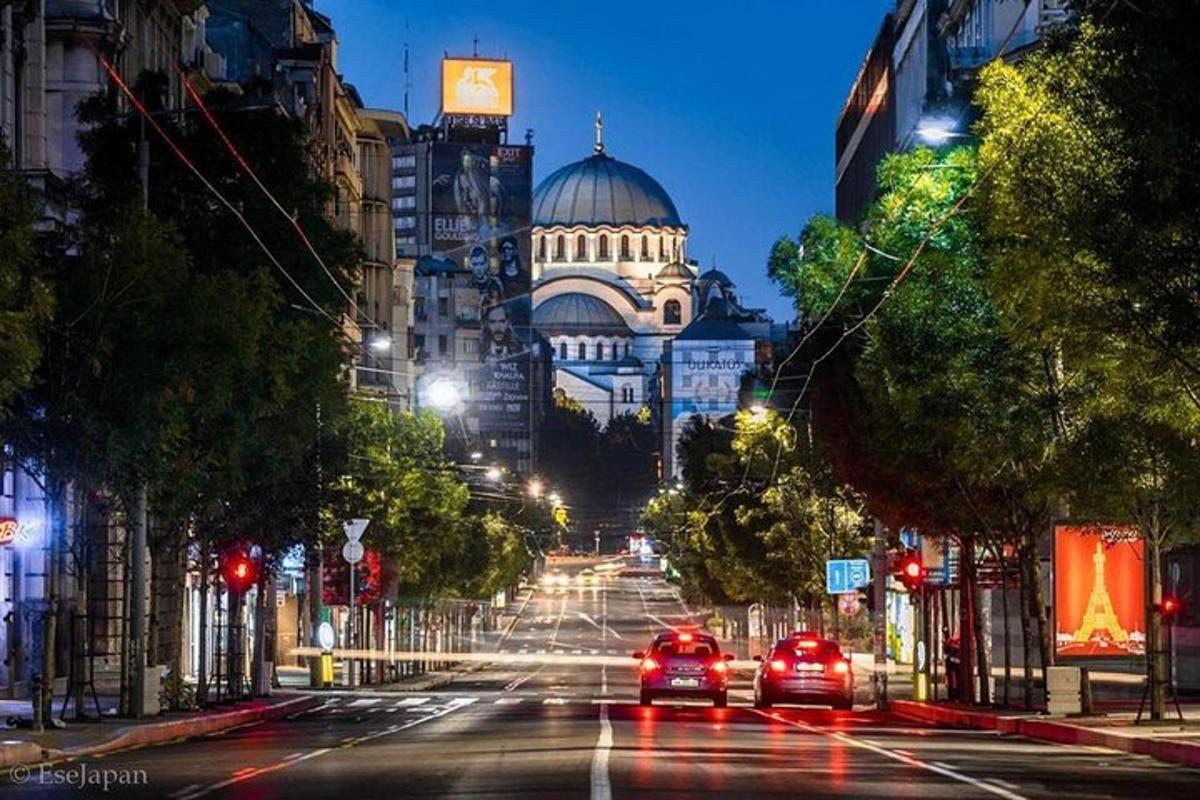 una strada cittadina di notte con le auto che la percorrono