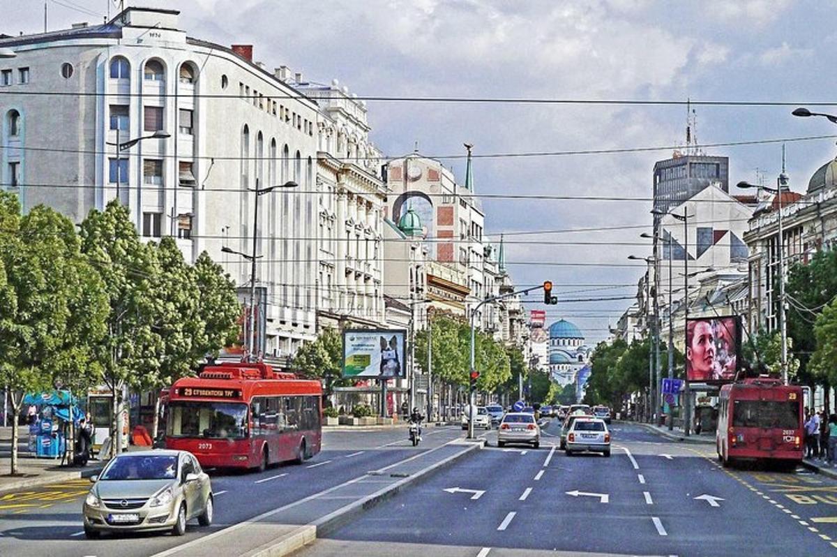 una strada cittadina trafficata con auto e un autobus rosso