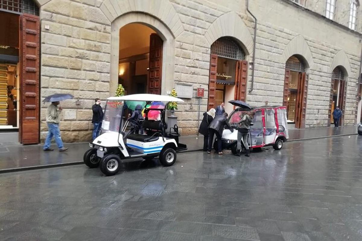to golfbiler parkert utenfor en bygning i regnet
