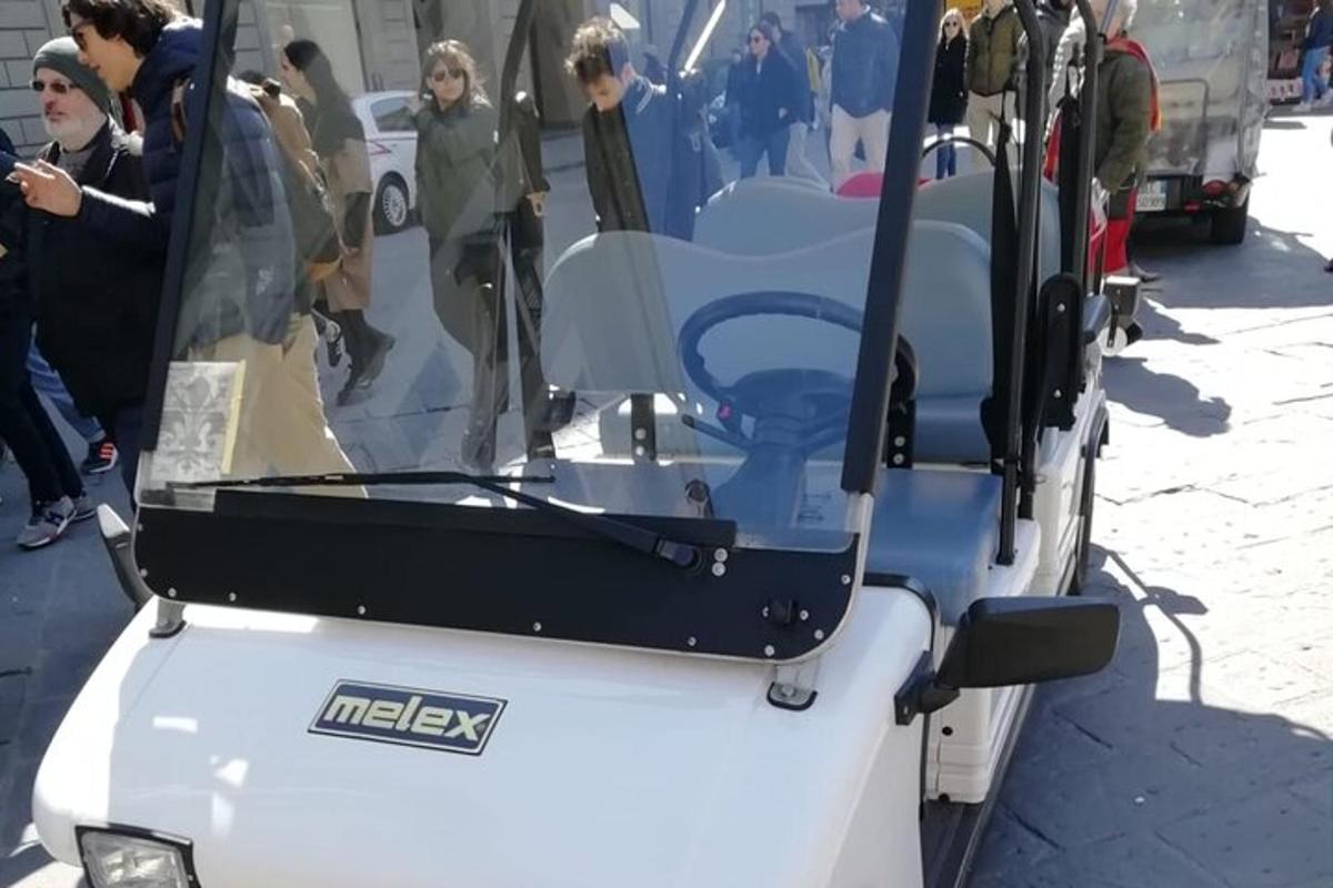 un gruppo di persone in piedi attorno a un autobus bianco
