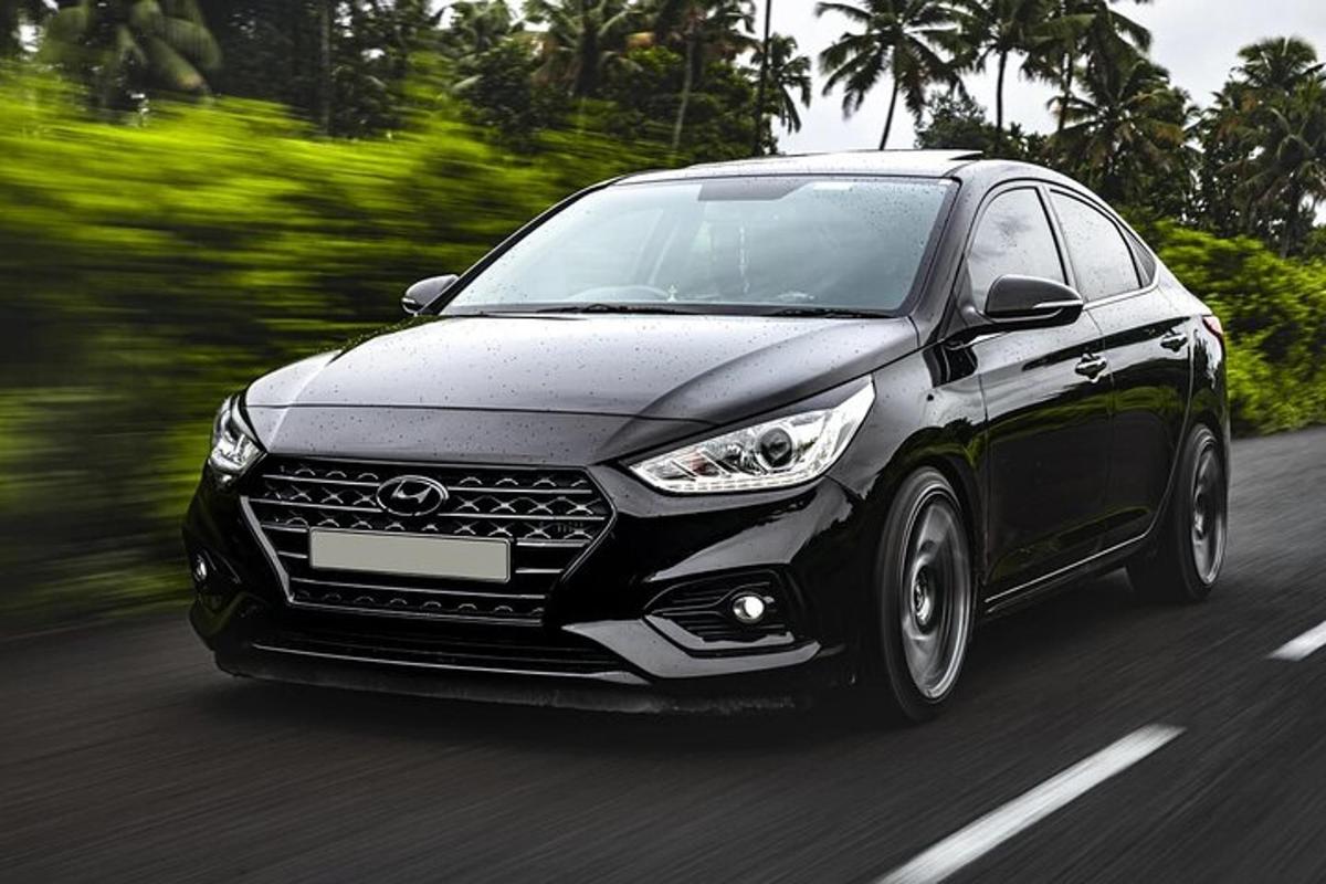 um carro preto está dirigindo por uma estrada