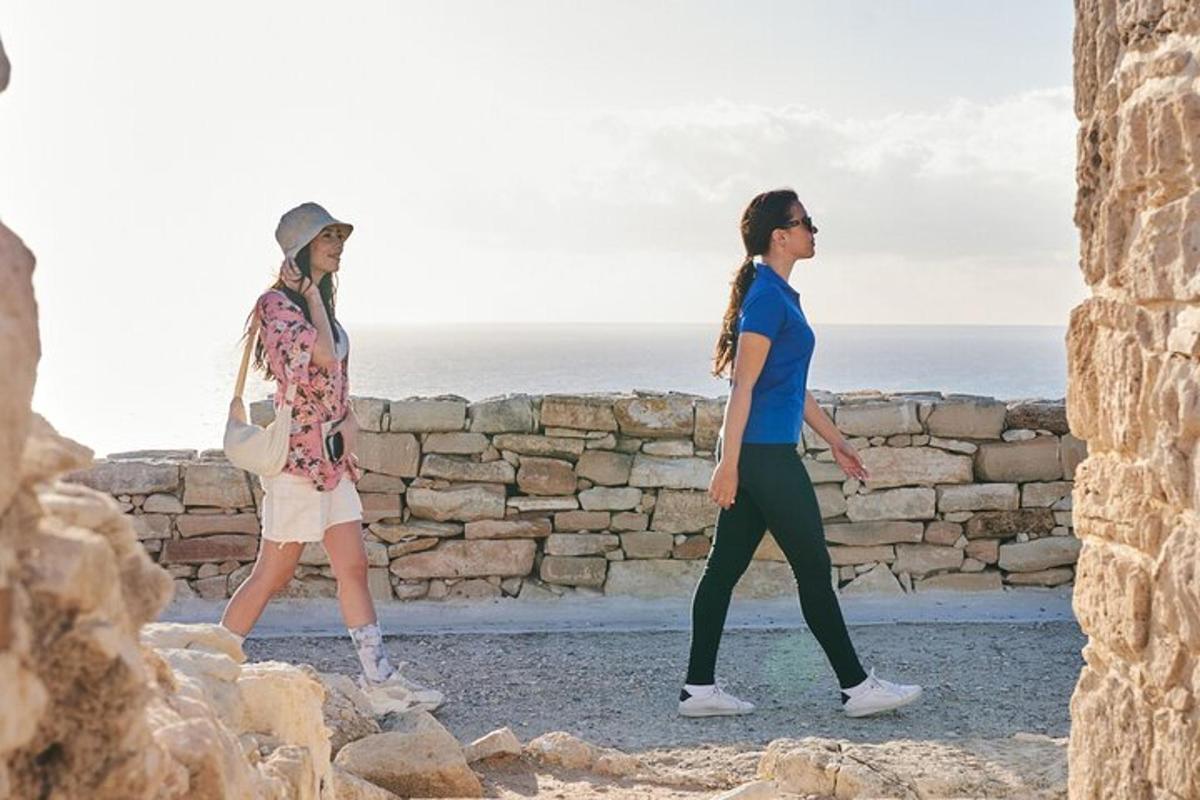 two women walking along a stone wall