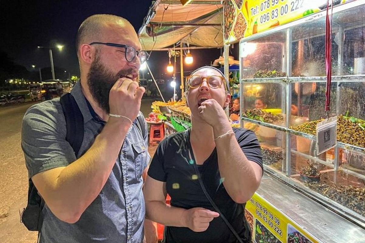 dos homes menjant davant d'un mercat