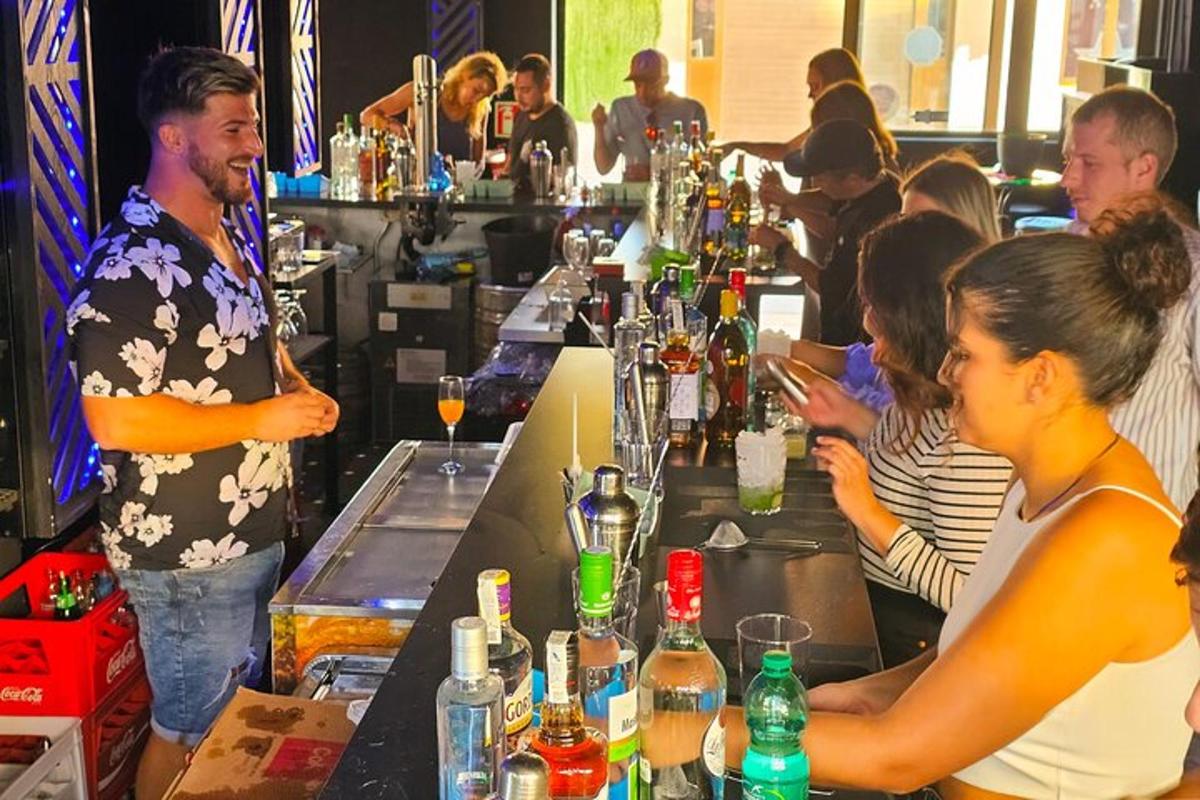 skupina lidí sedících u baru s drinky