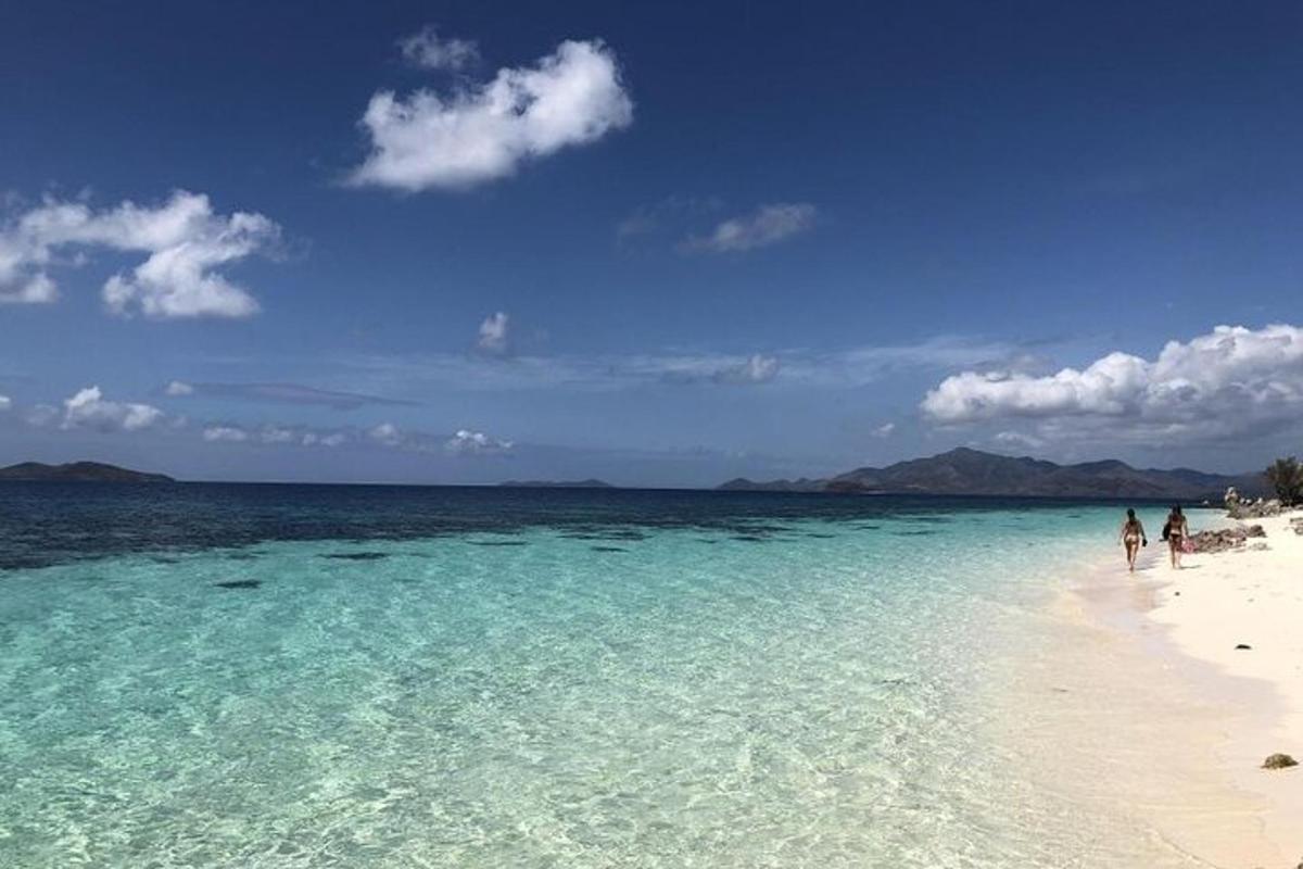 a beach with turquoise water and people on it
