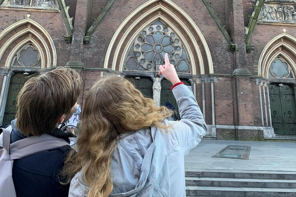 Tvær stúlkur standa fyrir framan kirkju með fingur á lofti