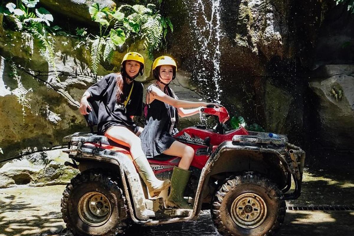 dua orang gadis menaiki atv di hadapan air terjun