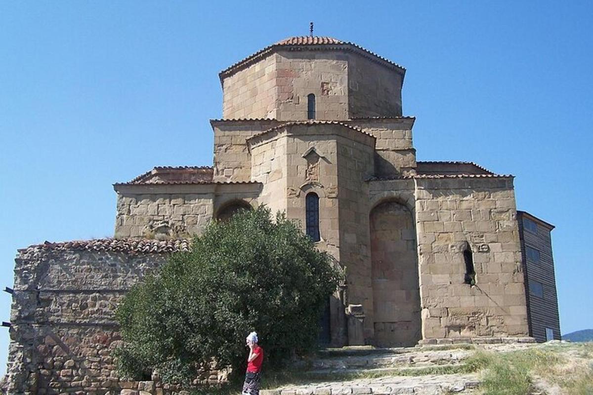 una persona in piedi davanti a un edificio in pietra