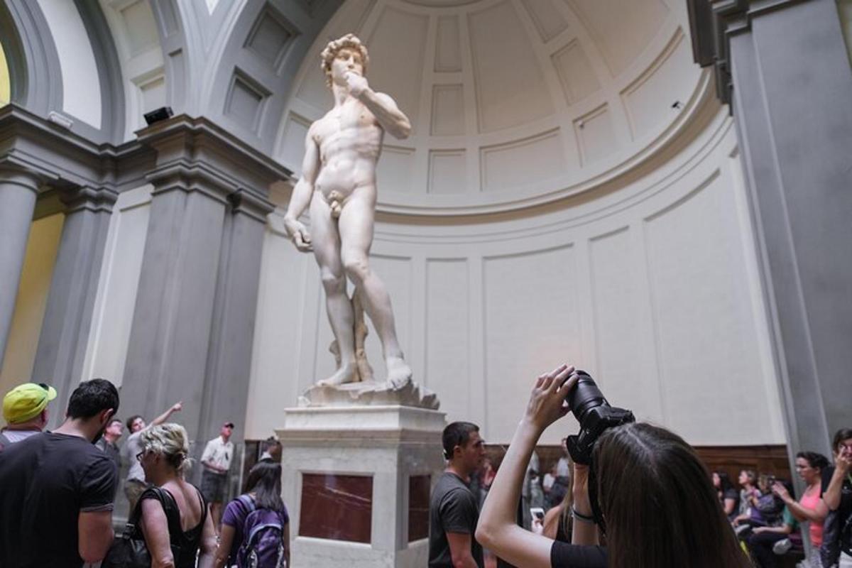un gruppo di persone che scatta foto di una statua in un museo