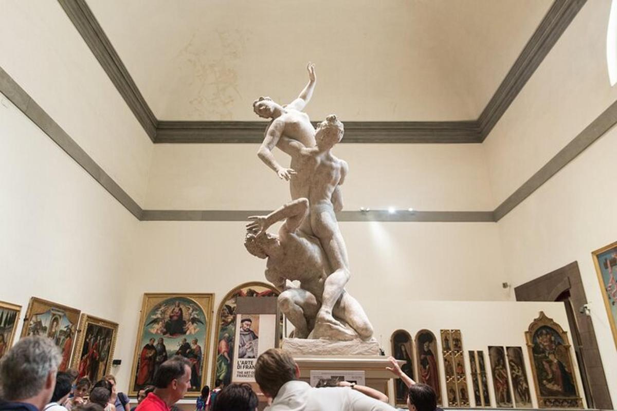 a crowd of people looking at a statue in a museum