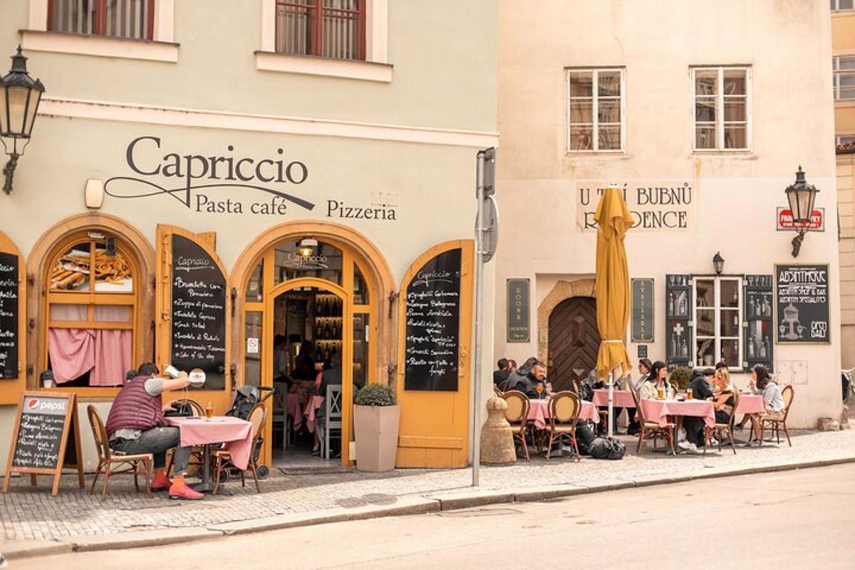 skupina lidí sedících u stolů před restaurací