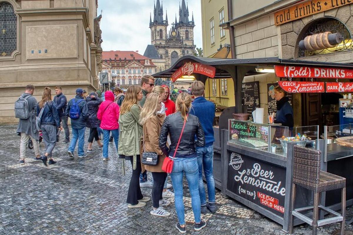 skupina lidí stojících kolem stánku s občerstvením na ulici