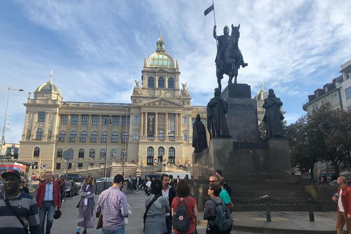 skupina lidí stojících kolem sochy před budovou