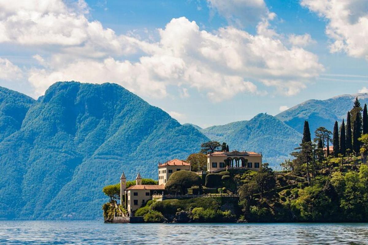 una casa su un'isola nell'acqua con le montagne