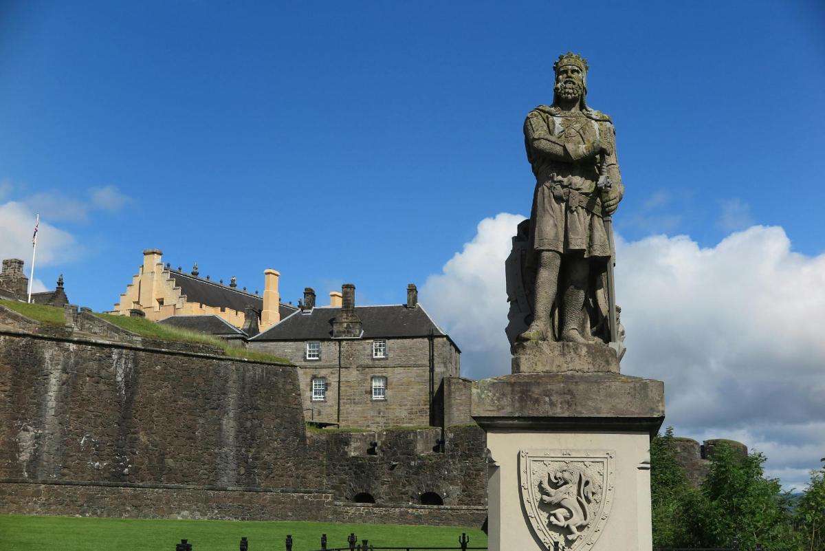 eine Statue eines Mannes vor einem Schloss