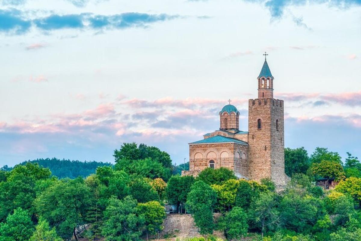 un edifici antic al cim d'un turó amb arbres