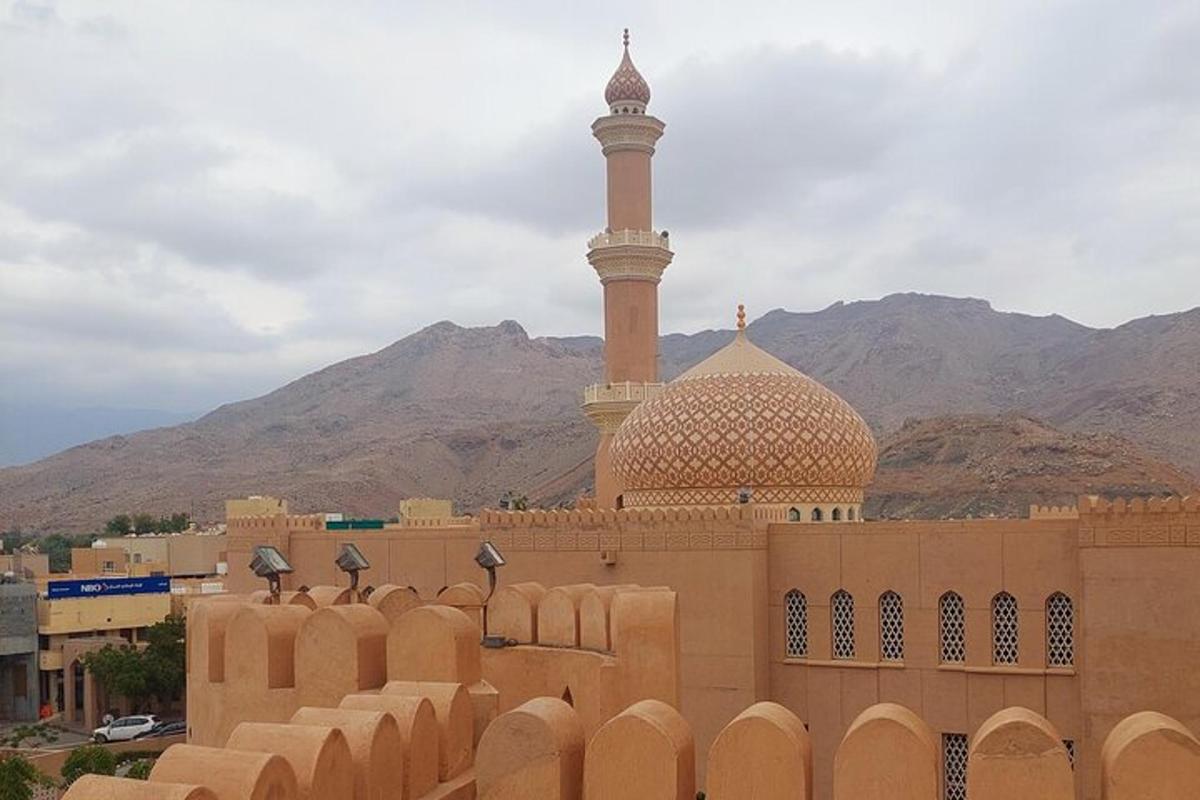a mosque with a minaret in the middle of a city